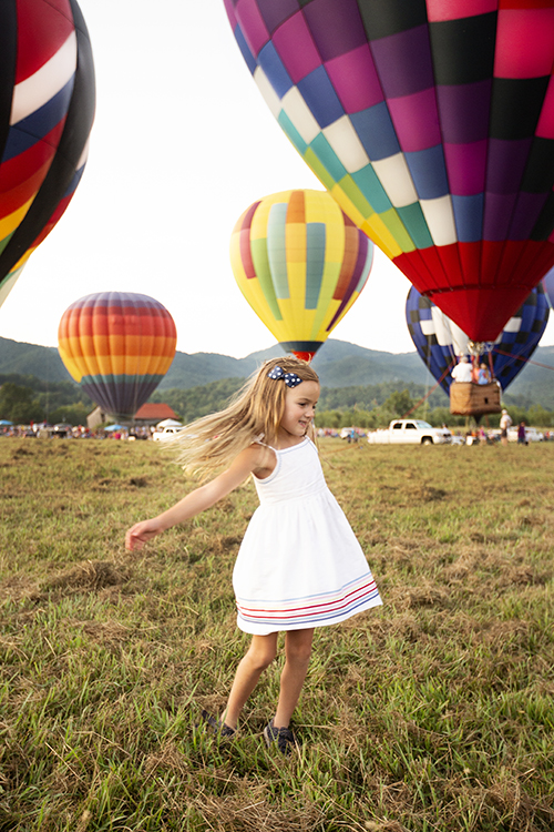 girl twirling at hot air balloon festival