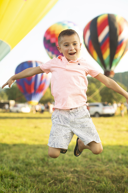 boy jumping at hot air balloon festival