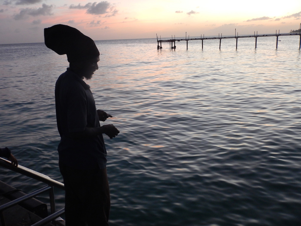 caribbean sun silhouettes pier fisherman
